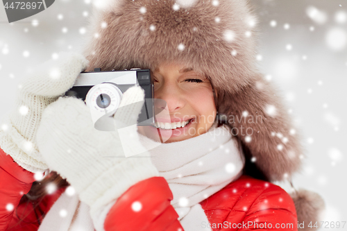 Image of happy woman with film camera outdoors in winter