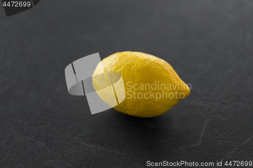 Image of close up of whole lemon on slate table top