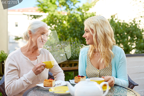 Image of daughter with senior mother drinking tea at cafe