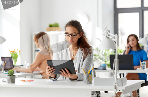 Image of businesswoman with tablet pc working at office
