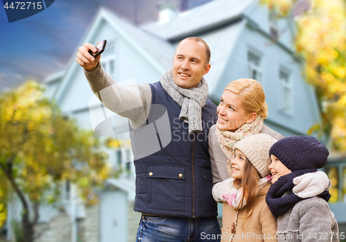 Image of family takes autumn selfie by cellphone over house