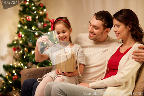 Image of happy family with christmas present at home