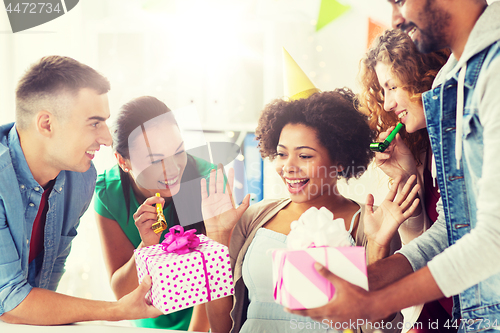 Image of team greeting colleague at office birthday party