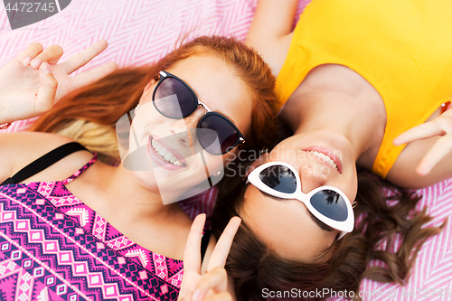 Image of teenage girls in sunglasses showing peace sign