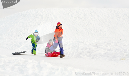 Image of happy kids with sled having fun outdoors in winter