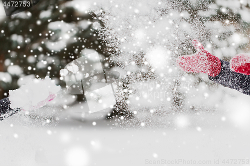 Image of happy friends playing with snow in winter