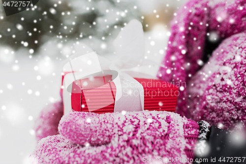 Image of close up of woman holding christmas gift outdoors