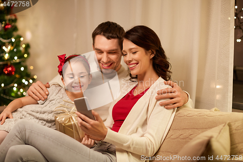 Image of family with smartphone at home on christmas