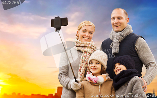 Image of family taking selfie over sunset in city