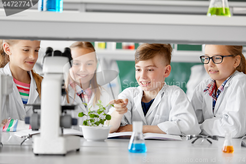 Image of kids or students with plant at biology class