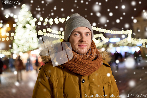 Image of happy man in winter clothes at christmas market