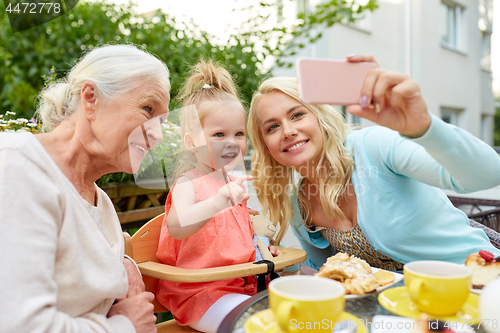 Image of happy family taking selfie at cafe