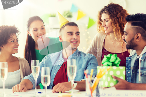 Image of team greeting colleague at office birthday party