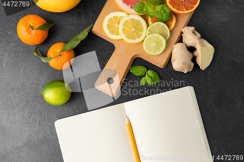 Image of close up of fruits and notebook on slate table top