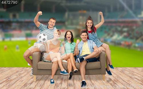 Image of friends or football fans with soccer ball on sofa