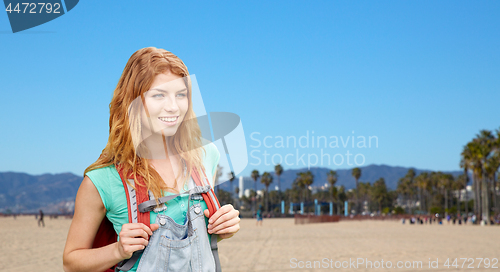 Image of smiling woman with backpack over venice beach