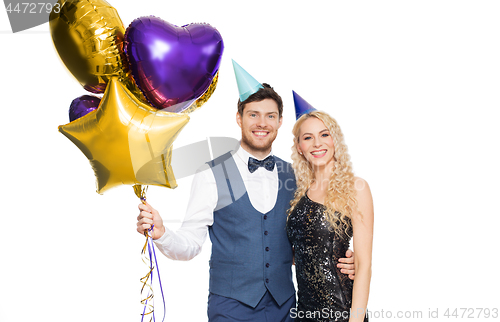 Image of happy couple with party caps and balloons