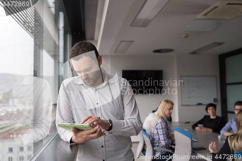 Image of Businessman Using Tablet In Office Building by window