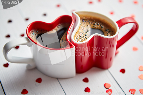 Image of Two heart shaped coffee cups conected with each other.