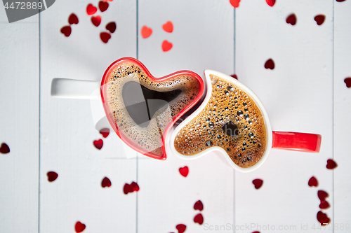 Image of Two heart shaped coffee cups conected with each other.