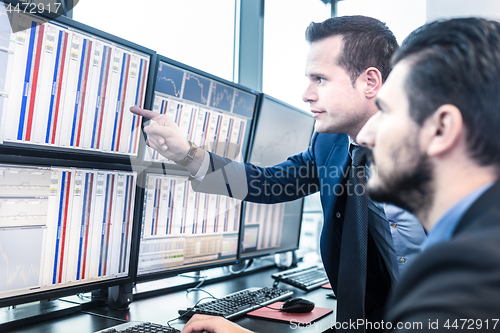 Image of Stock traders looking at market data on computer screens.