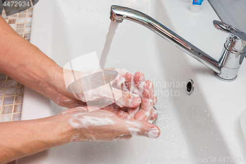 Image of Washing hands with soap in the sink