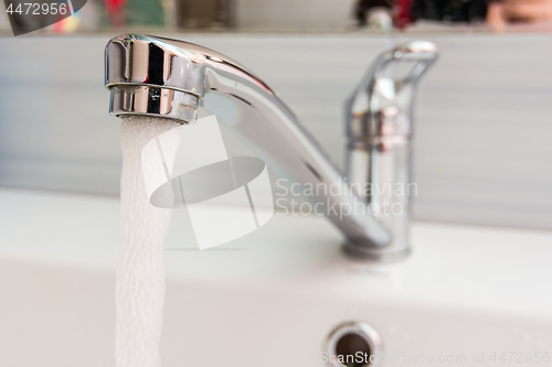 Image of Faucet in the bathroom, water pours out of it