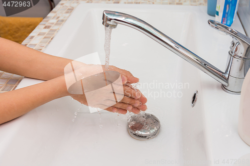 Image of Baby washes his hands in the bathroom