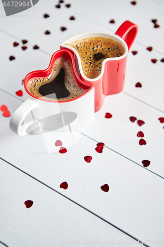 Image of Two heart shaped coffee cups conected with each other.