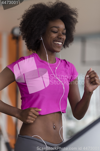 Image of afro american woman running on a treadmill