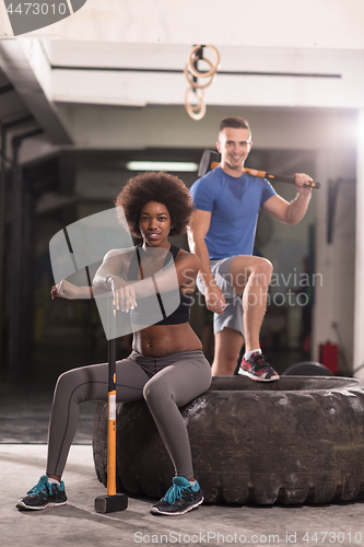 Image of multiethnic couple after workout with hammer