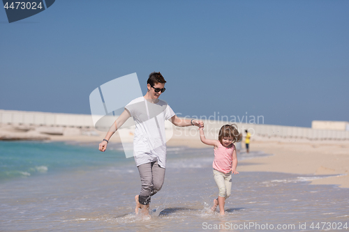 Image of mother and daughter running on the beach