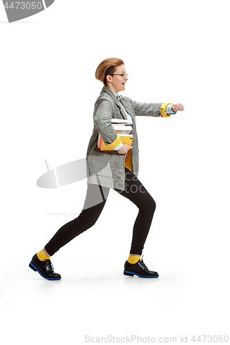 Image of Full length portrait of a happy smiling female student holding books isolated on white background
