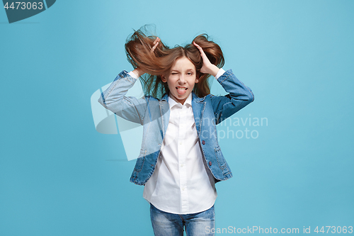 Image of The squint eyed teen girl with weird expression isolated on blue