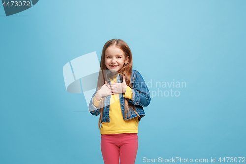 Image of The happy teen girl standing and smiling against pink background.