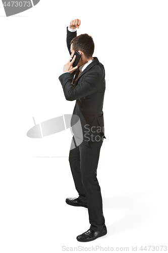 Image of Thee profile portrait of a businessman with very serious face. Confident professional with mobile phone