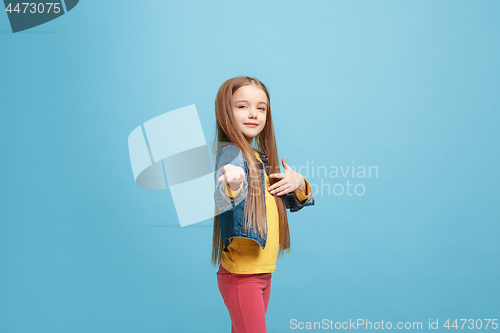 Image of The happy teen girl standing and smiling against pink background.