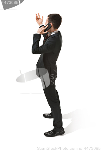 Image of Thee profile portrait of a businessman with very serious face. Confident professional with mobile phone