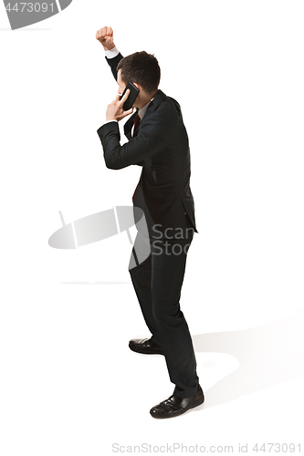 Image of Thee profile portrait of a businessman with very serious face. Confident professional with mobile phone