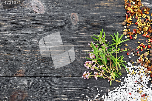 Image of Thyme leaves and flowers with spices on black board