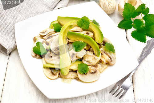 Image of Salad of avocado and champignons on wooden table