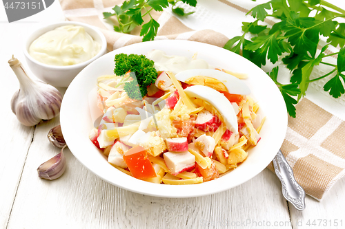 Image of Salad of surimi and tomatoes with eggs on wooden board