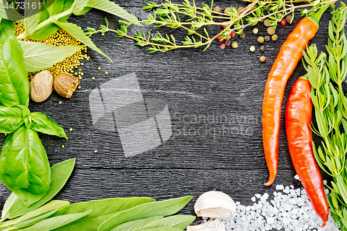 Image of Frame from herbs and pepper on black wooden board