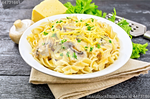 Image of Fusilli with mushrooms and cream on black board