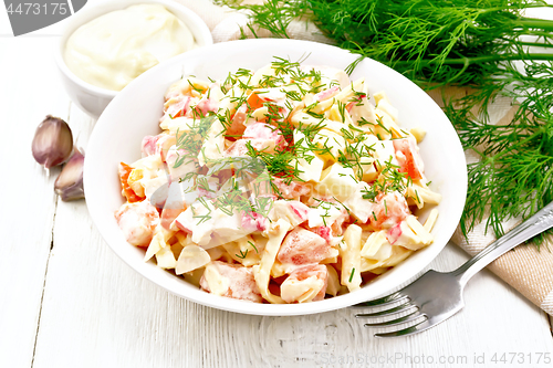 Image of Salad of surimi and eggs with mayonnaise on light board