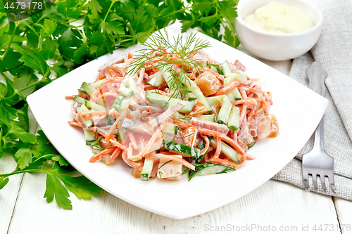 Image of Salad of sausage and spicy carrots with mayonnaise on white boar