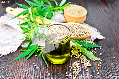 Image of Oil hemp in jar with flour and grain on wooden board