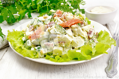 Image of Salad of salmon and avocado with mayonnaise on light wooden boar