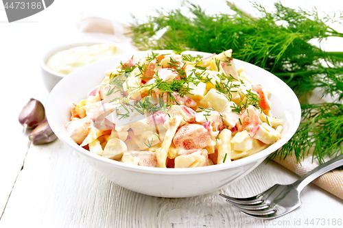 Image of Salad of surimi and eggs with mayonnaise on wooden board