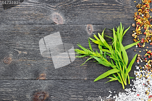 Image of Tarragon leaves with spices on black board